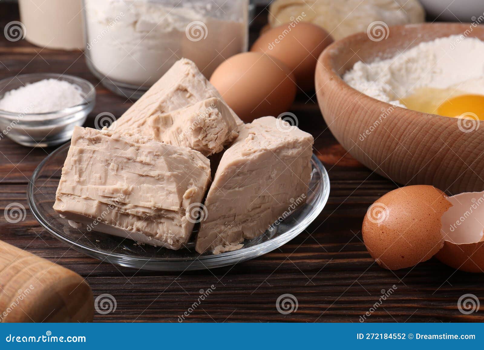 Compressed Yeast, Eggs, Salt, Dough and Flour on Table Stock Photo