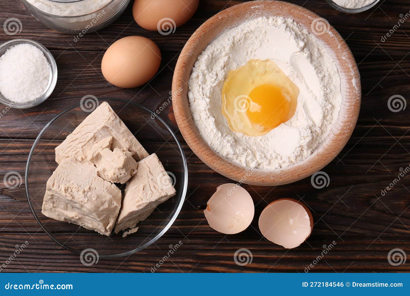 Compressed Yeast, Flour, Salt and Eggs on Wooden Table Stock Photo
