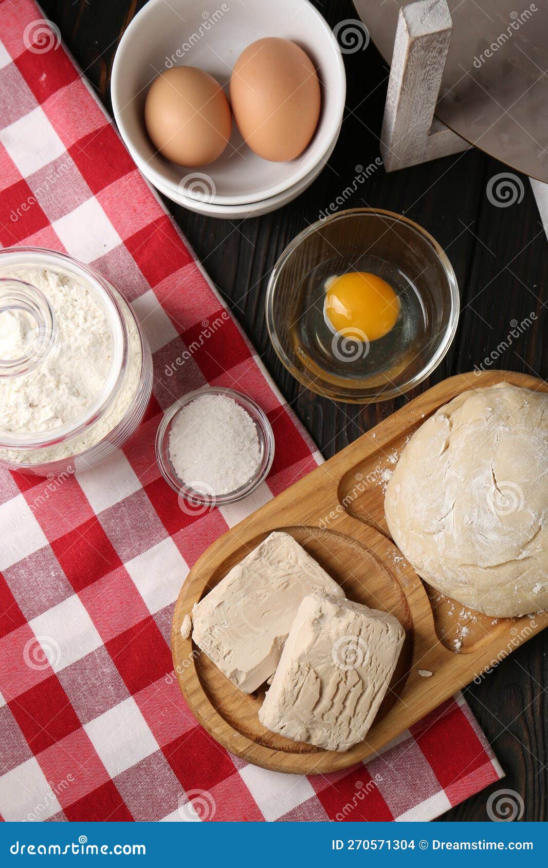 Compressed Yeast, Salt, Flour, Eggs and Dough on Wooden Table, Flat Lay
