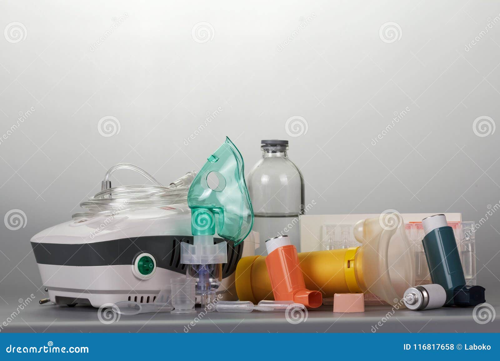compressor and portable inhalers, replaceable dispenser, ampoules and baby mask, on grey