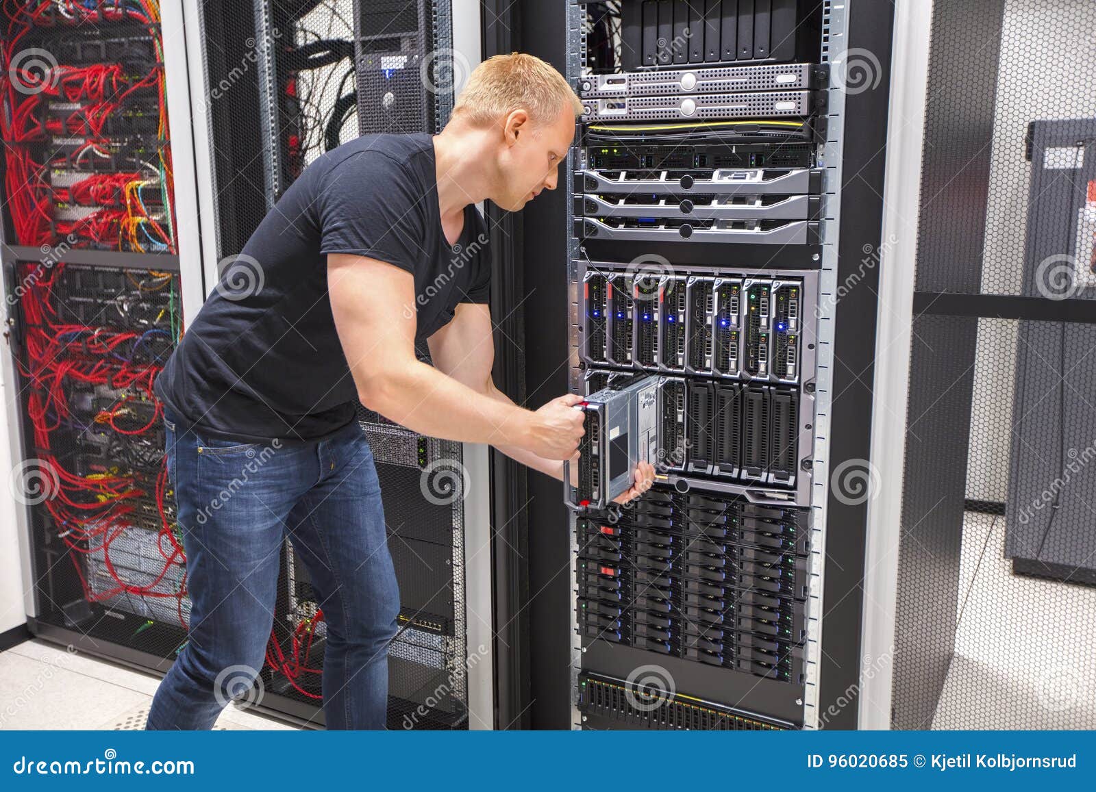 computer engineer installing blade server in datacenter