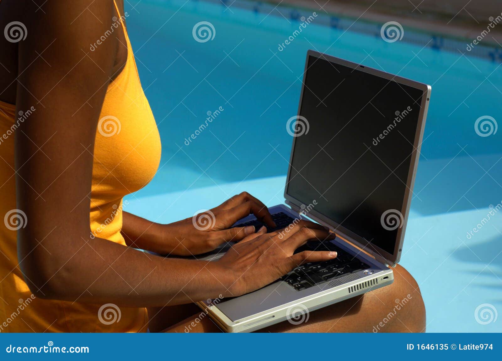 Looking down on female woman in only bra with ample breasts cleavage using  laptop computer at night фотография Stock