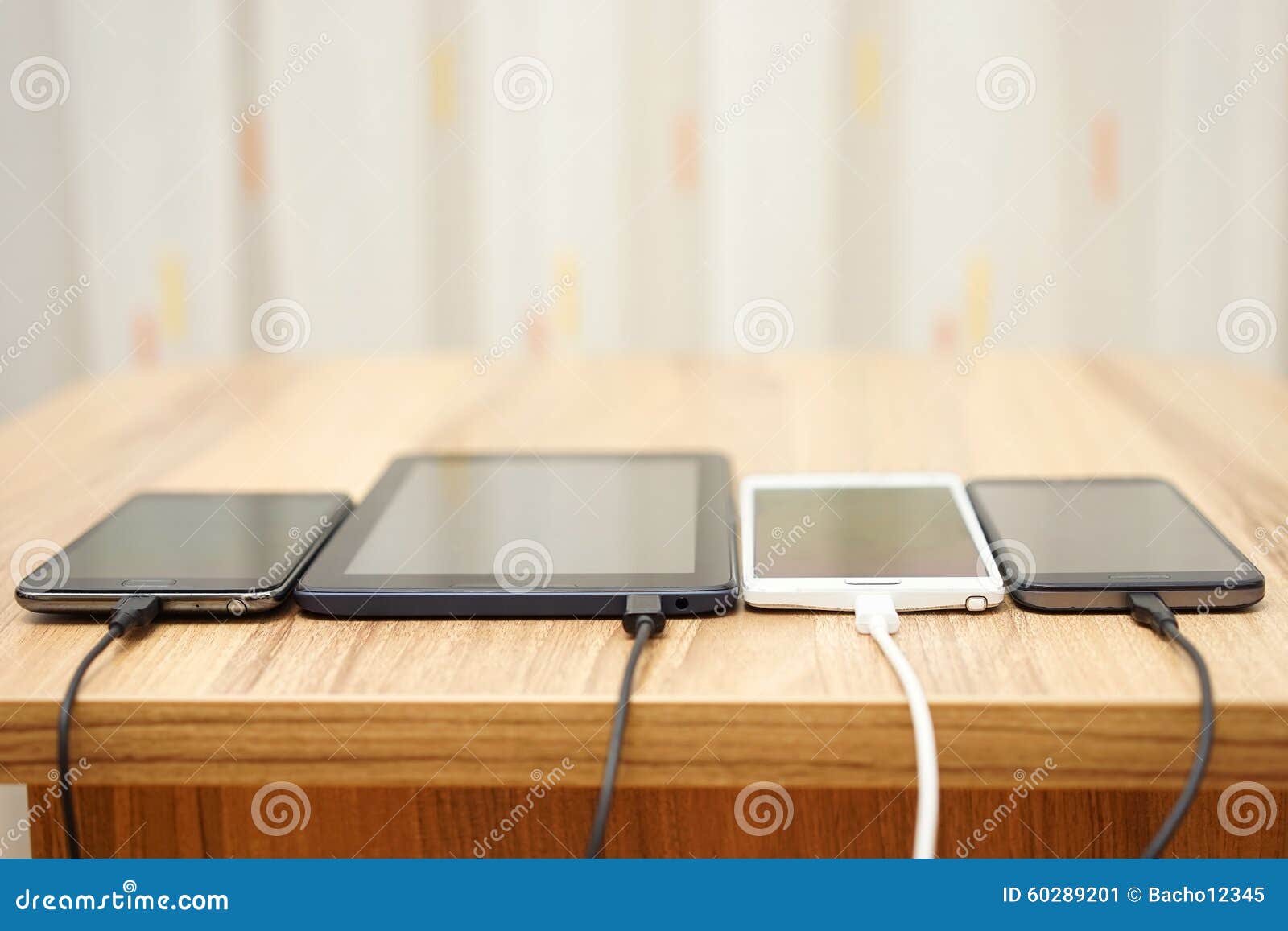Computer Tablet and Mobile Phones Charging on Home Desk Stock Image