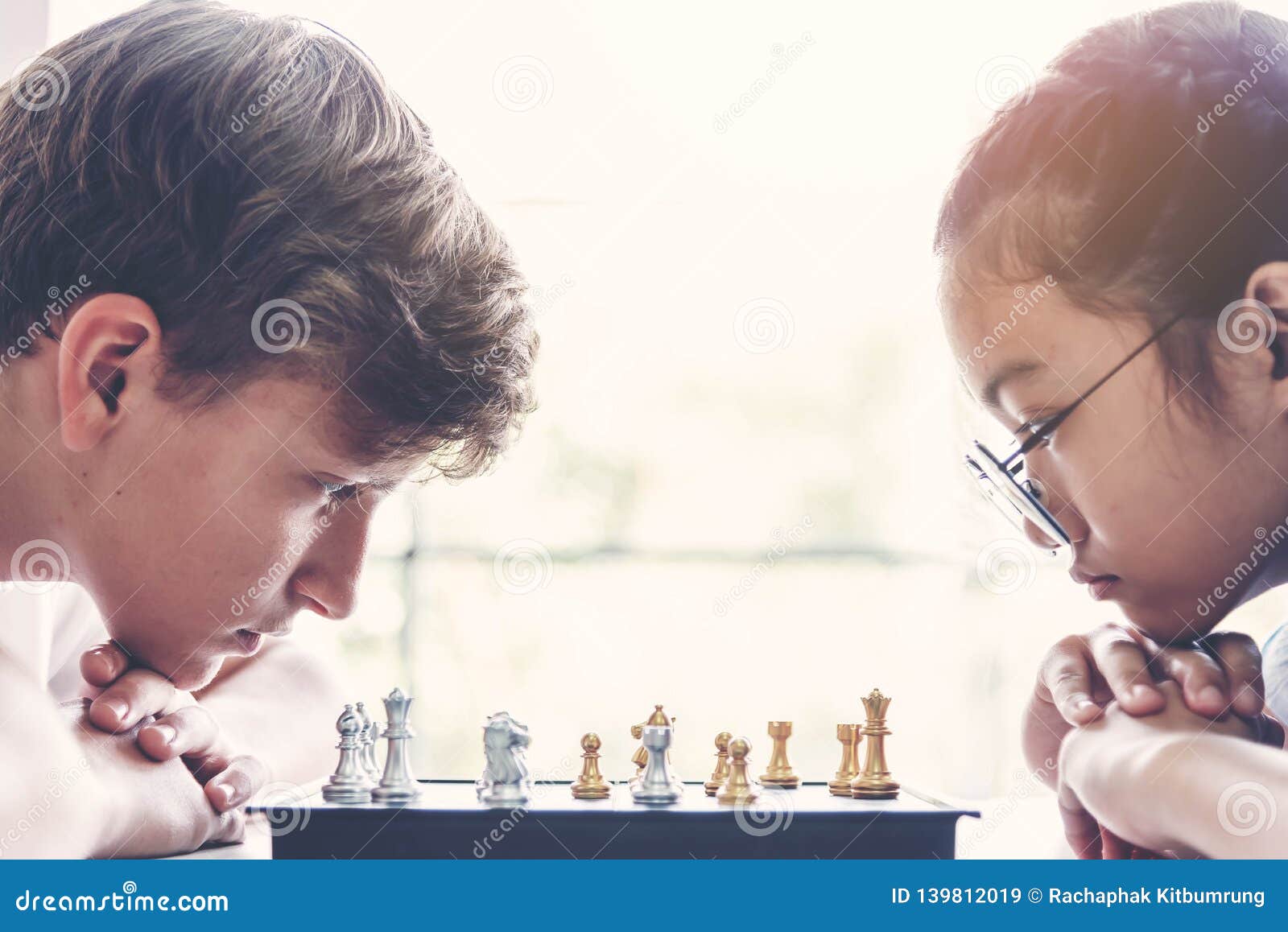 Concentrated serious boy developing chess gambit, strategy ,playing board  game to winner clever concentration and thinking child while playing chess.  Learning, tactics and analysis concept. Free Photo