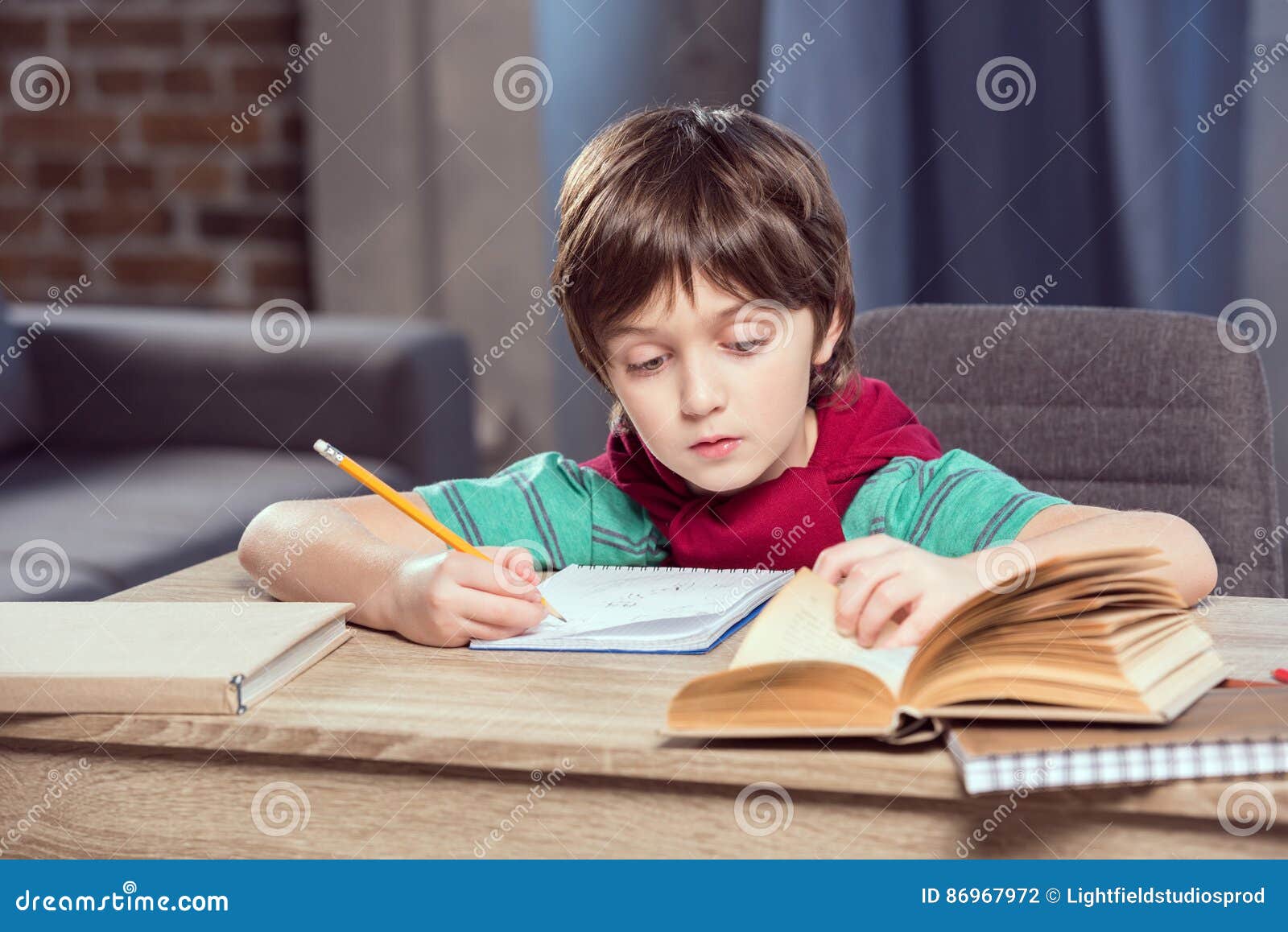 Concentrated Boy Sitting At Table And Doing Homework Stock ...