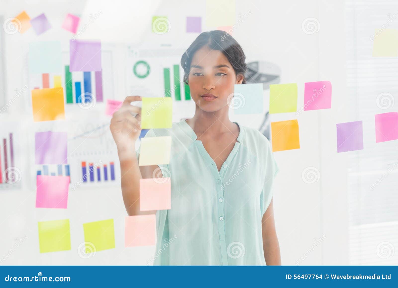 Concentrated Businesswoman Looking Post Its on the Wall Stock Photo