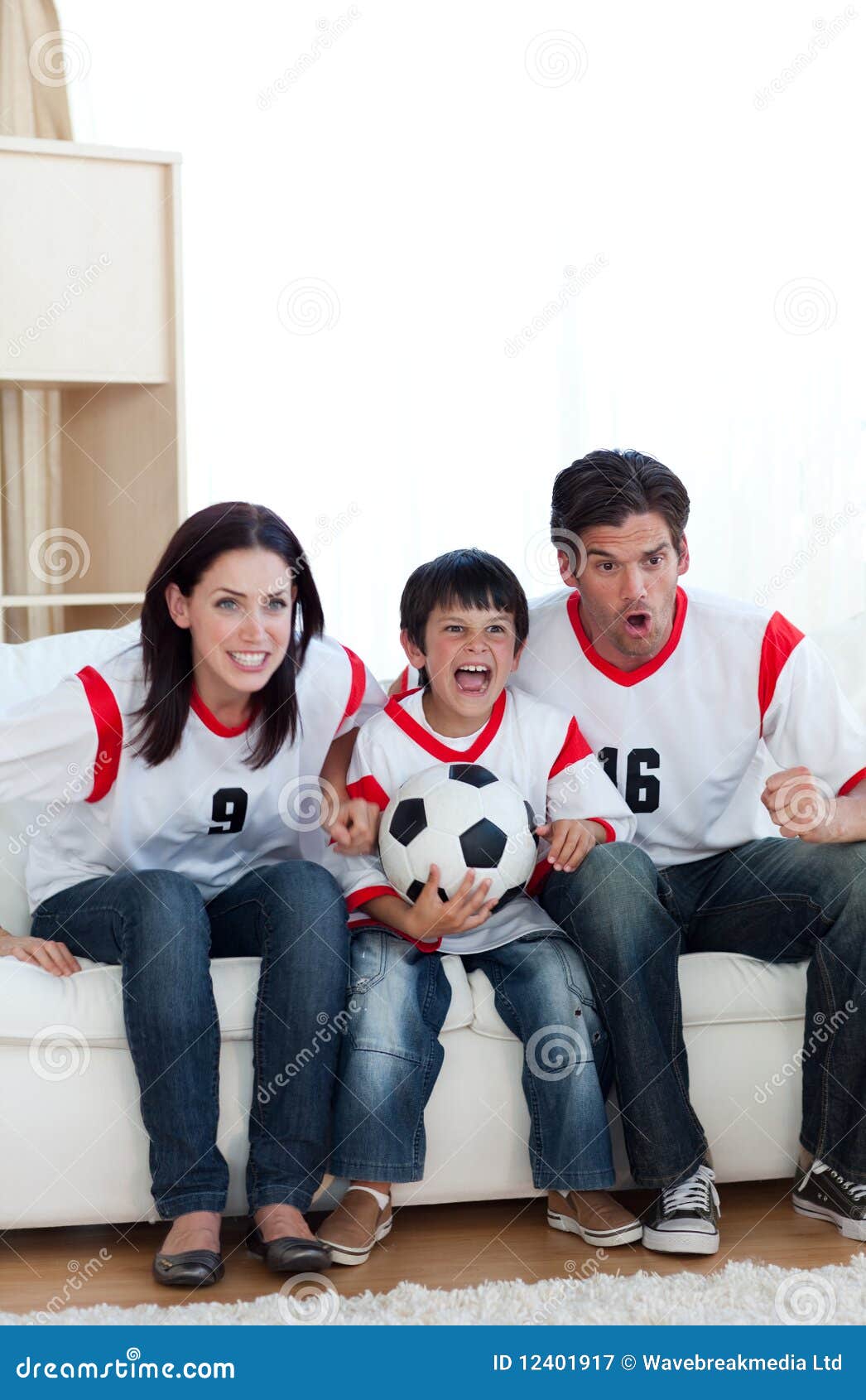 Concentrated Family Watching Football Match on Tv Stock Image