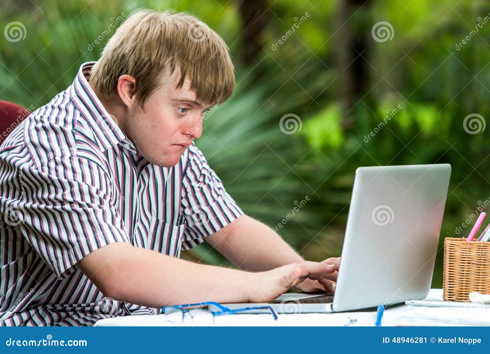 Concentrated Handicapped Boy Typing On Laptop. Stock Image - Image of