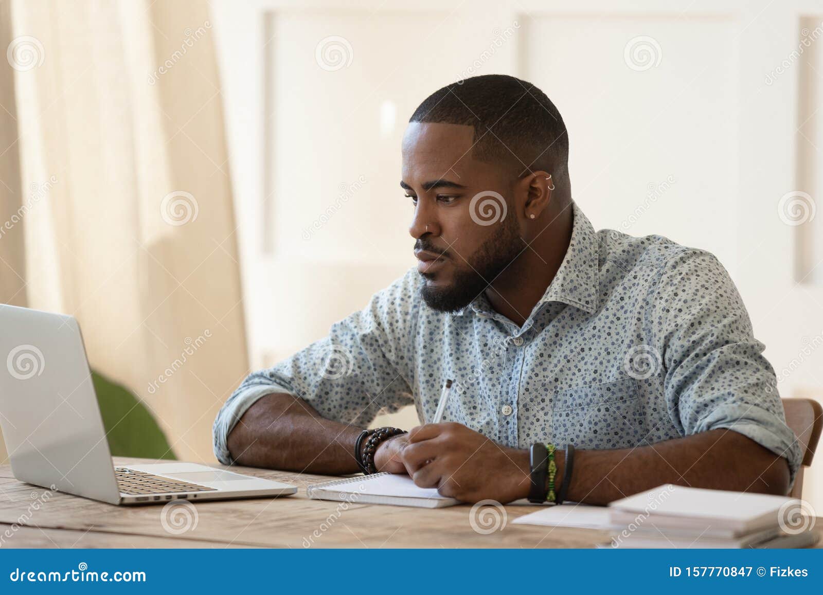 concentrated millennial african american guy focused on online university courses.
