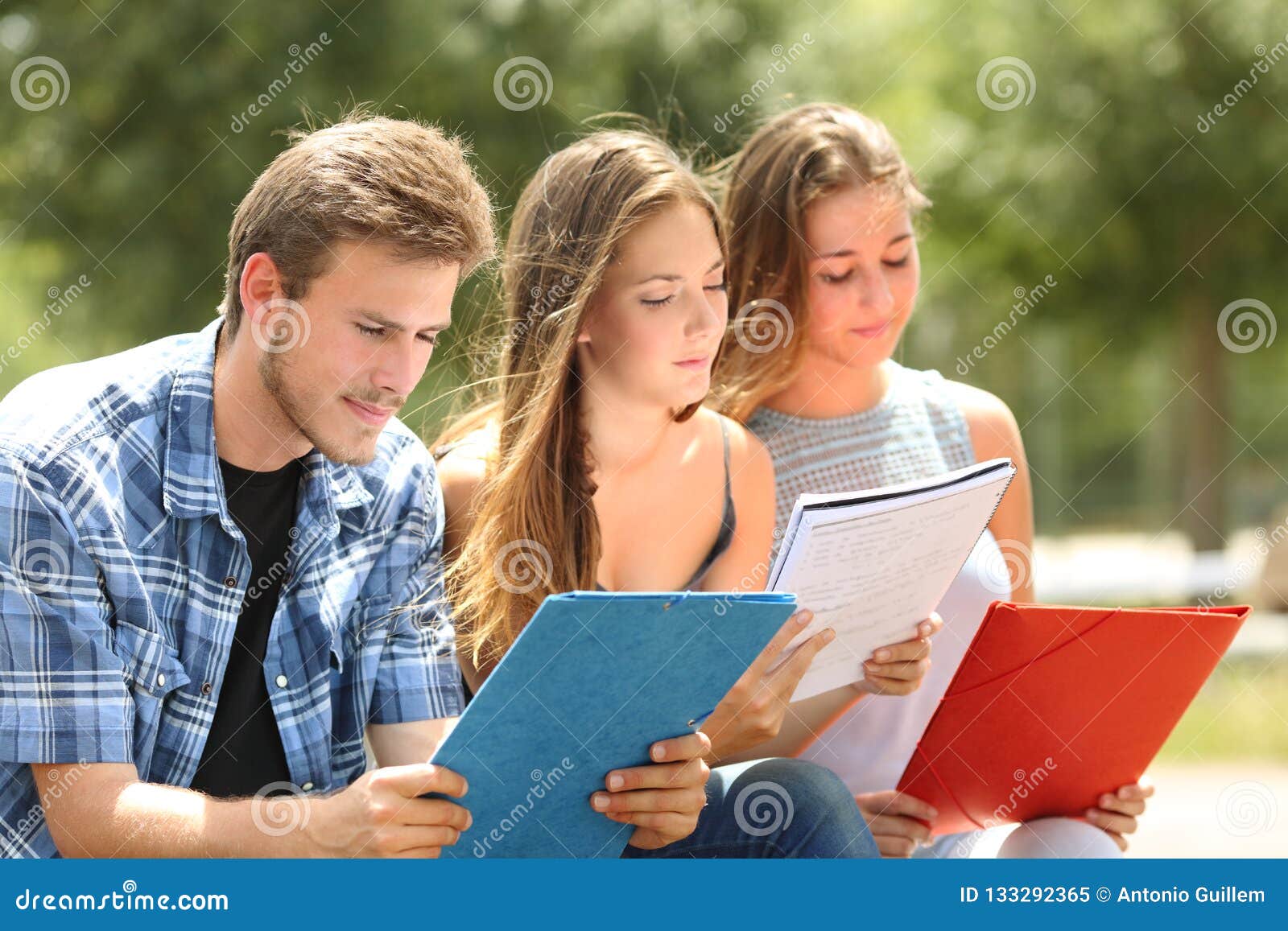 concentrated students memorizing in a campus park