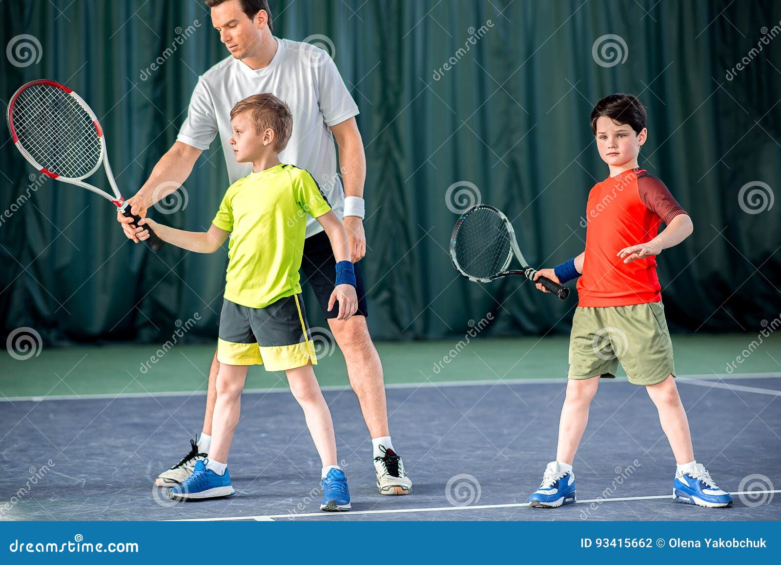 Concentrated Tennis Player Teaching Kids On Court Stock