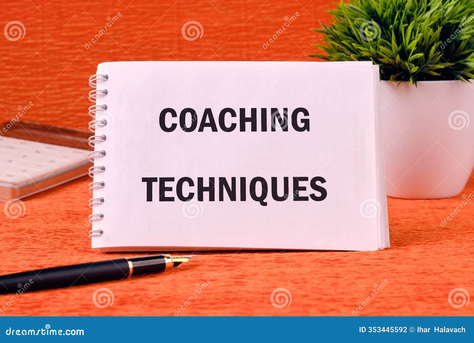 concept of business and development. conceptual text coaching techniques written on a clean notebook on an orange