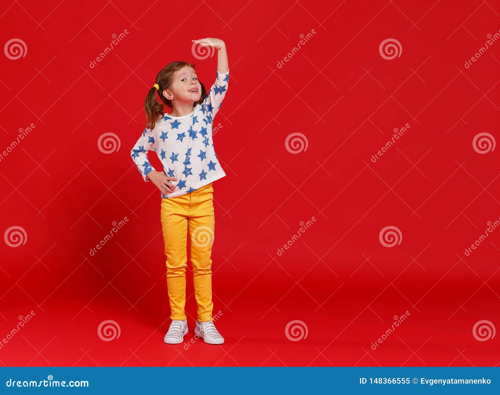 concept of development and growth,   kid girl measuring height on  red colored background