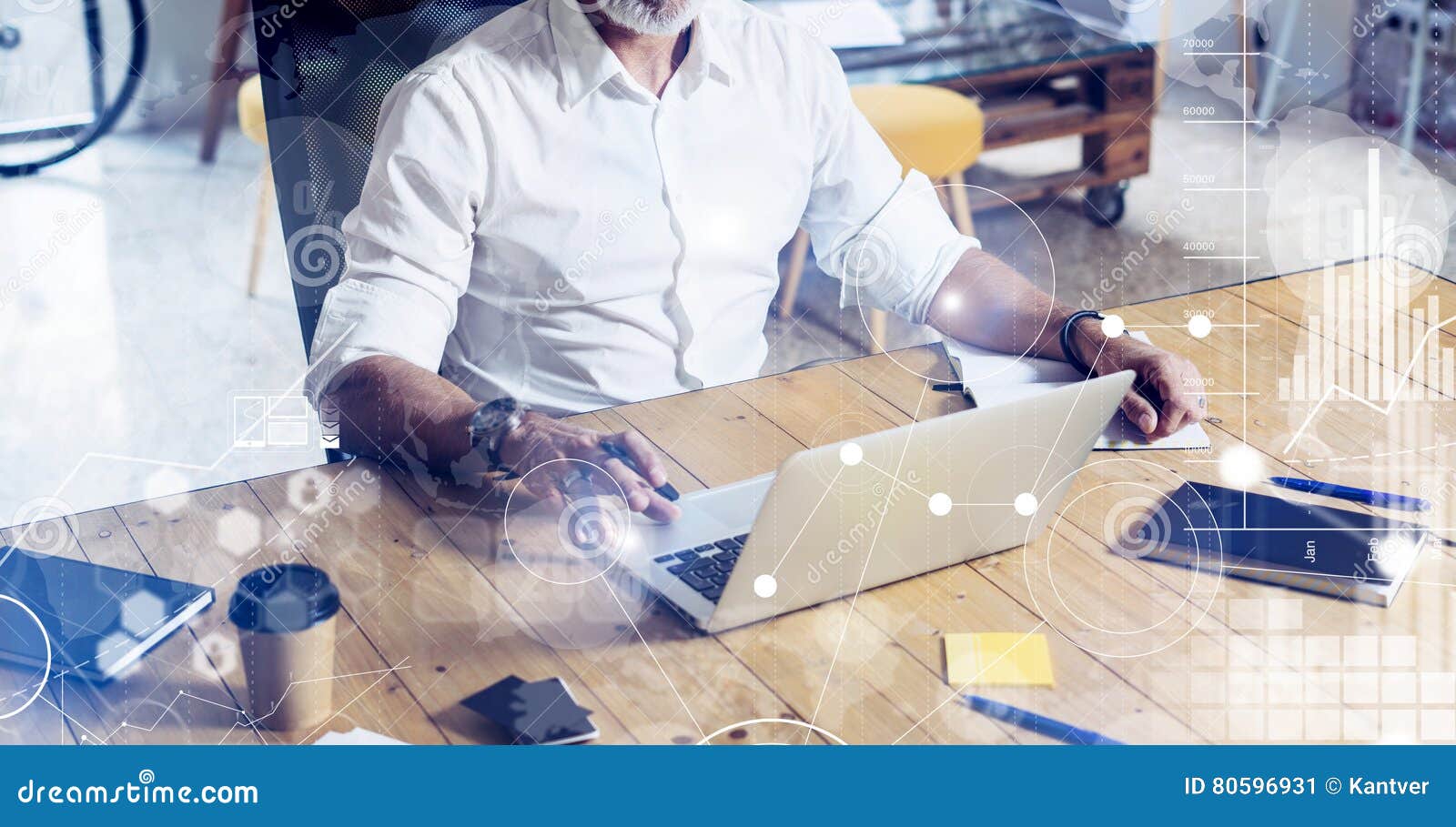 Concept of digital screen with virtual icon,diagram, graph and interfaces.Stylish bearded middle age man using laptop on workplace. Horizontal wide, blurred background