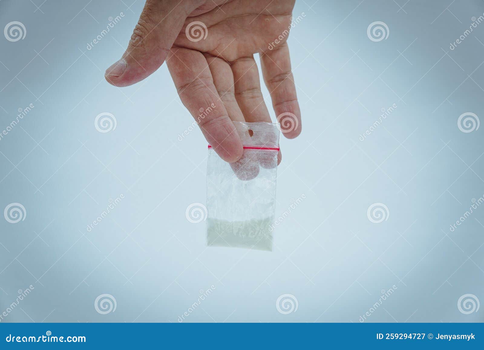 Young addicted man with cocain packet sitting - Stock Photo