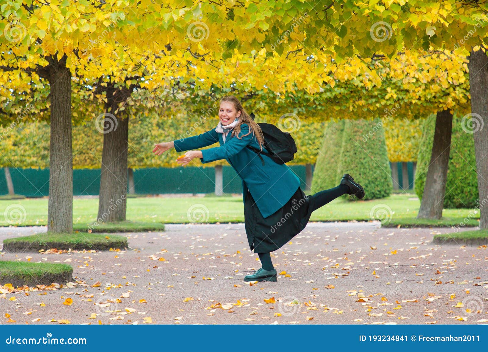 the concept of haste and tardiness. a woman is fooling around and having fun in the park, against the background of yellow trees