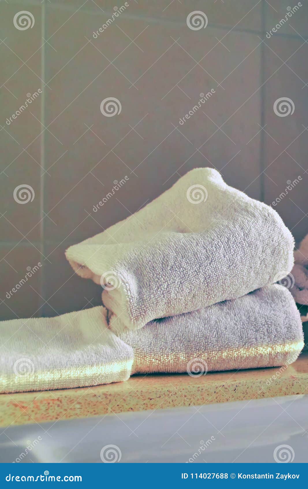 Concept of Hygiene. Stack of White Clean Towels at the Edge of the Bath