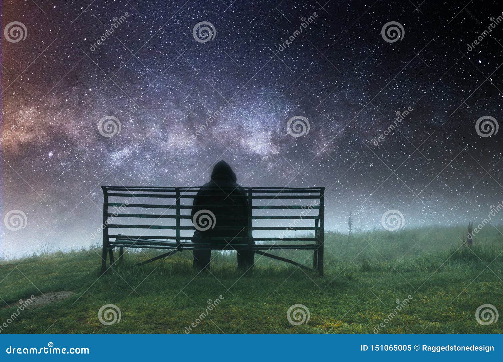 A Lone Hooded Man Sitting on a Bench in Th Rain, with a Sad, Muted ...