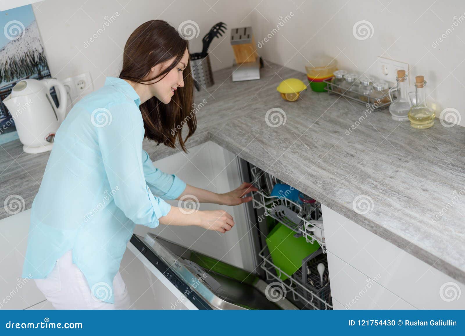 The Concept of Modern Washing Dishes, a Woman Pulls Clean Dishes from