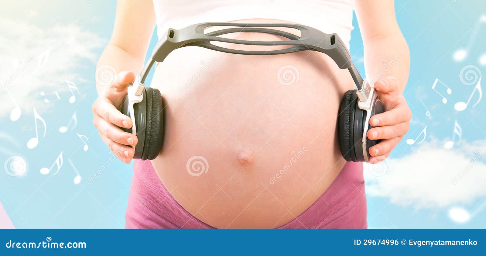 Pregnant woman listens to music on headphones, gently caresses her belly  thinking about her baby, enjoying her pregnancy 24697149 Stock Photo at  Vecteezy