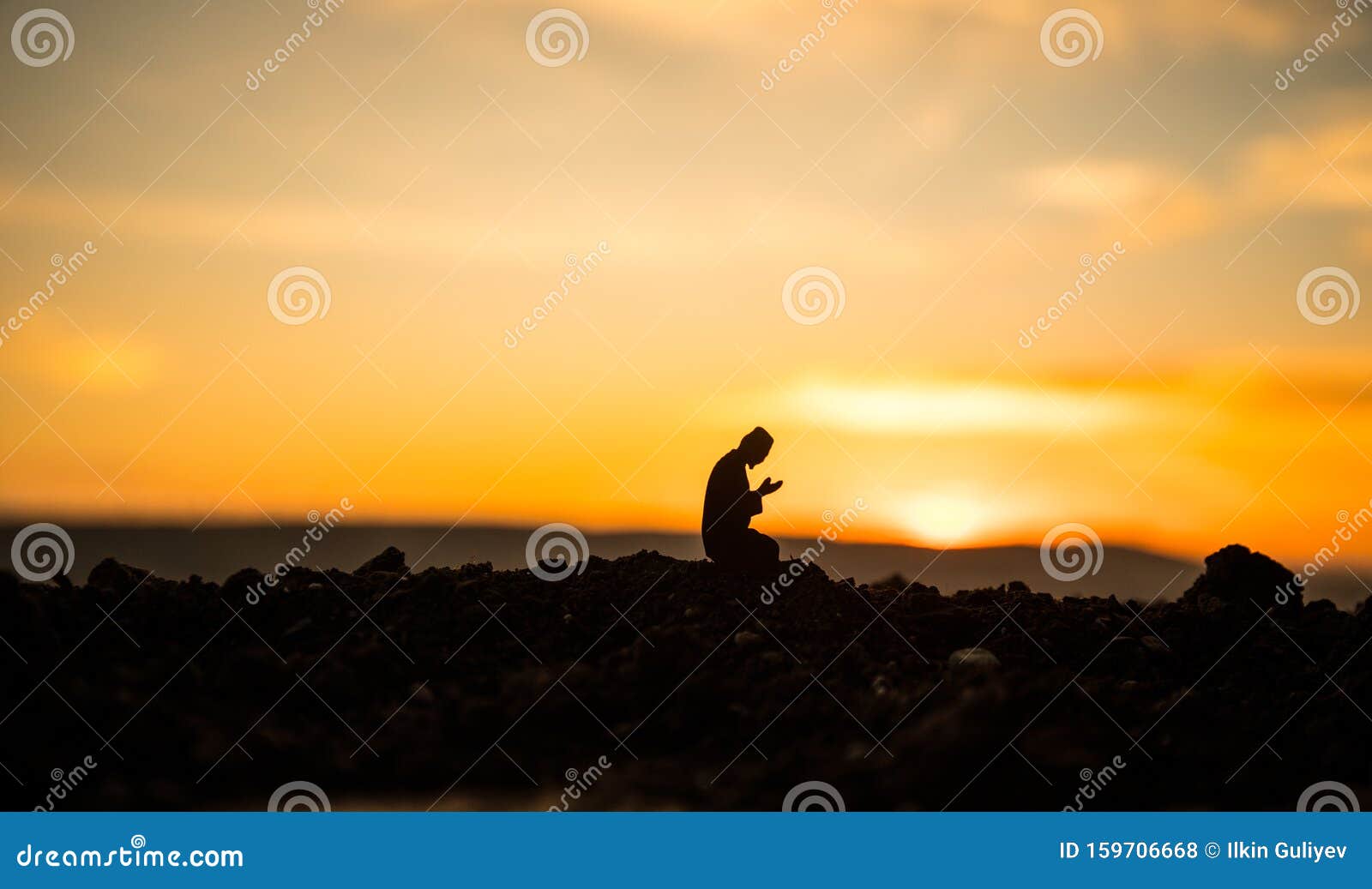 concept of religion islam. silhouette of man praying on the background of a mosque at sunset