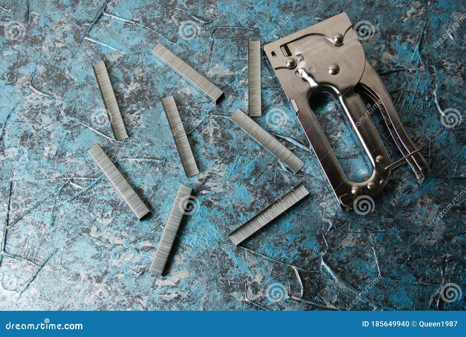 Concept of Repair and Construction. Construction Stapler and Staples on Blue Artistic Putty