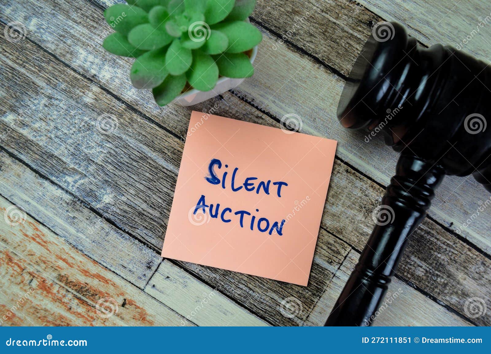 concept of silent auction write on sticky notes with gavel  on wooden table