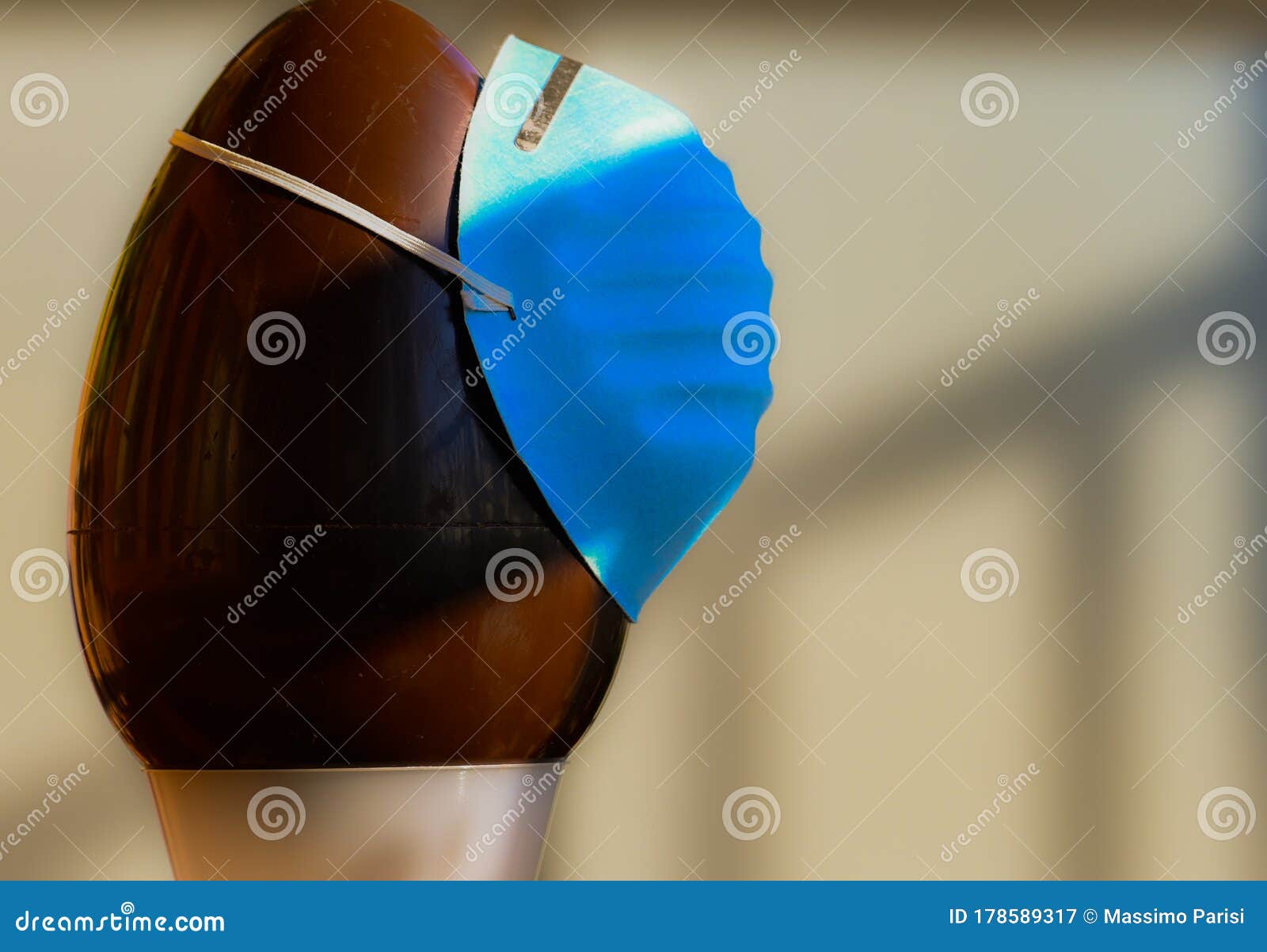 conceptual close-up image of easter at the time of the coronavirus pandemic. a chocolate egg, with an olive branch next to it,