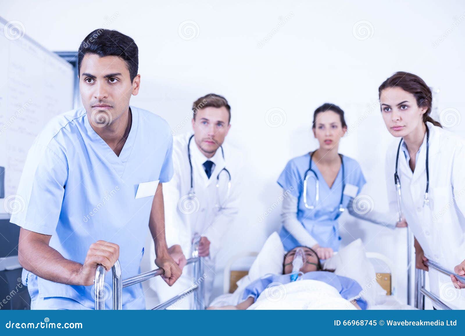 Concerned doctors standing near patient on bed in hospital