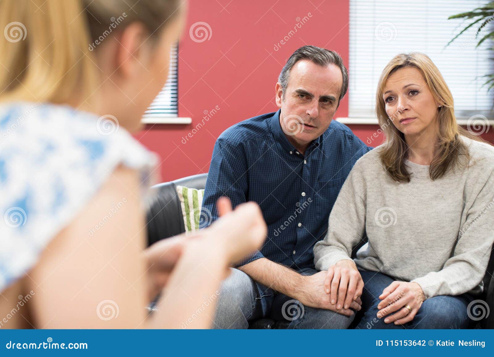 concerned mature couple talking with female counselor