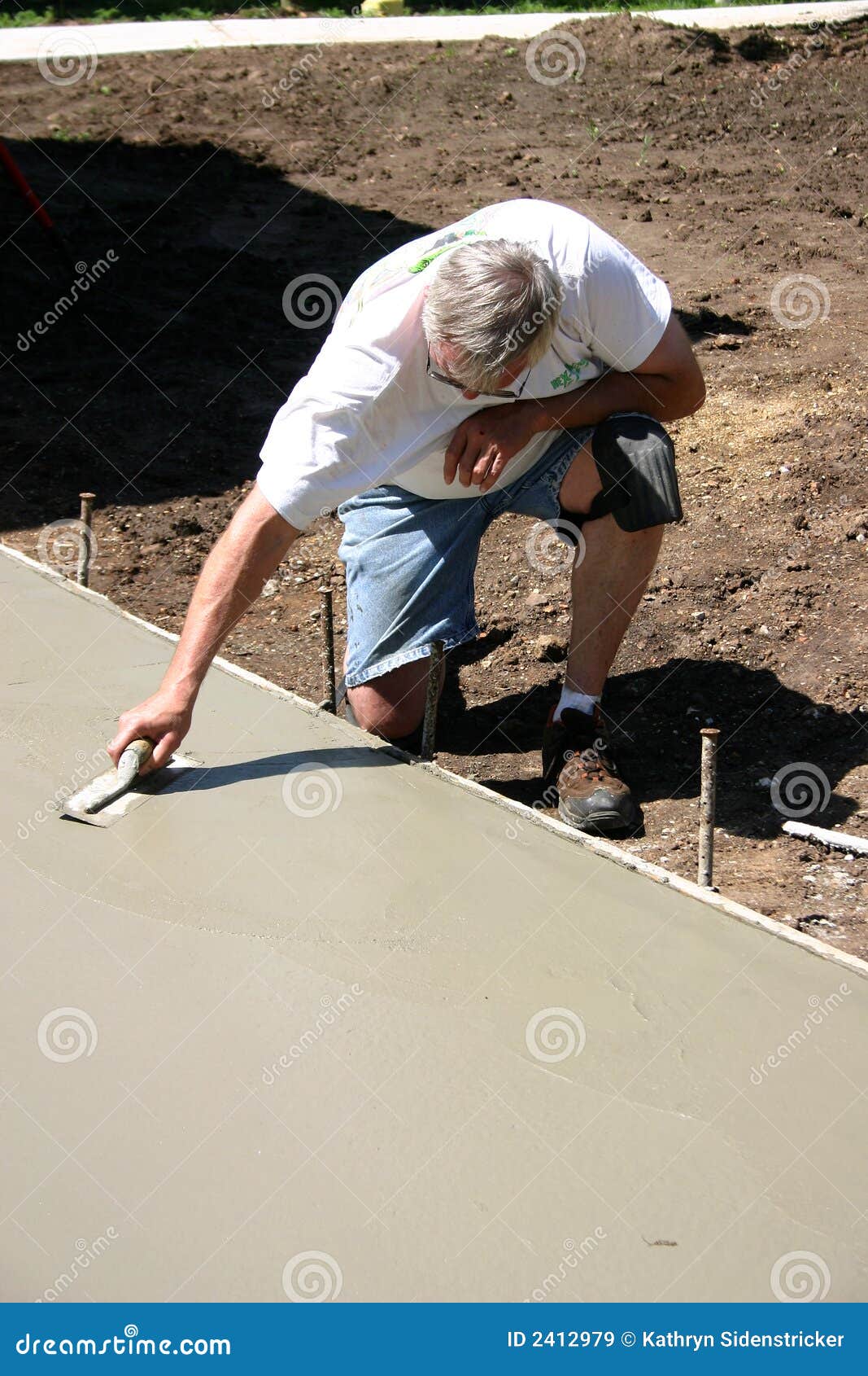 Concrete Finisher With Trowel Kneeling Royalty Free Stock Images