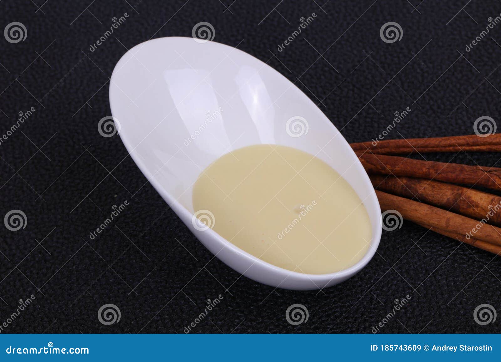 condenced milk in the bowl with sinnamon and pastry