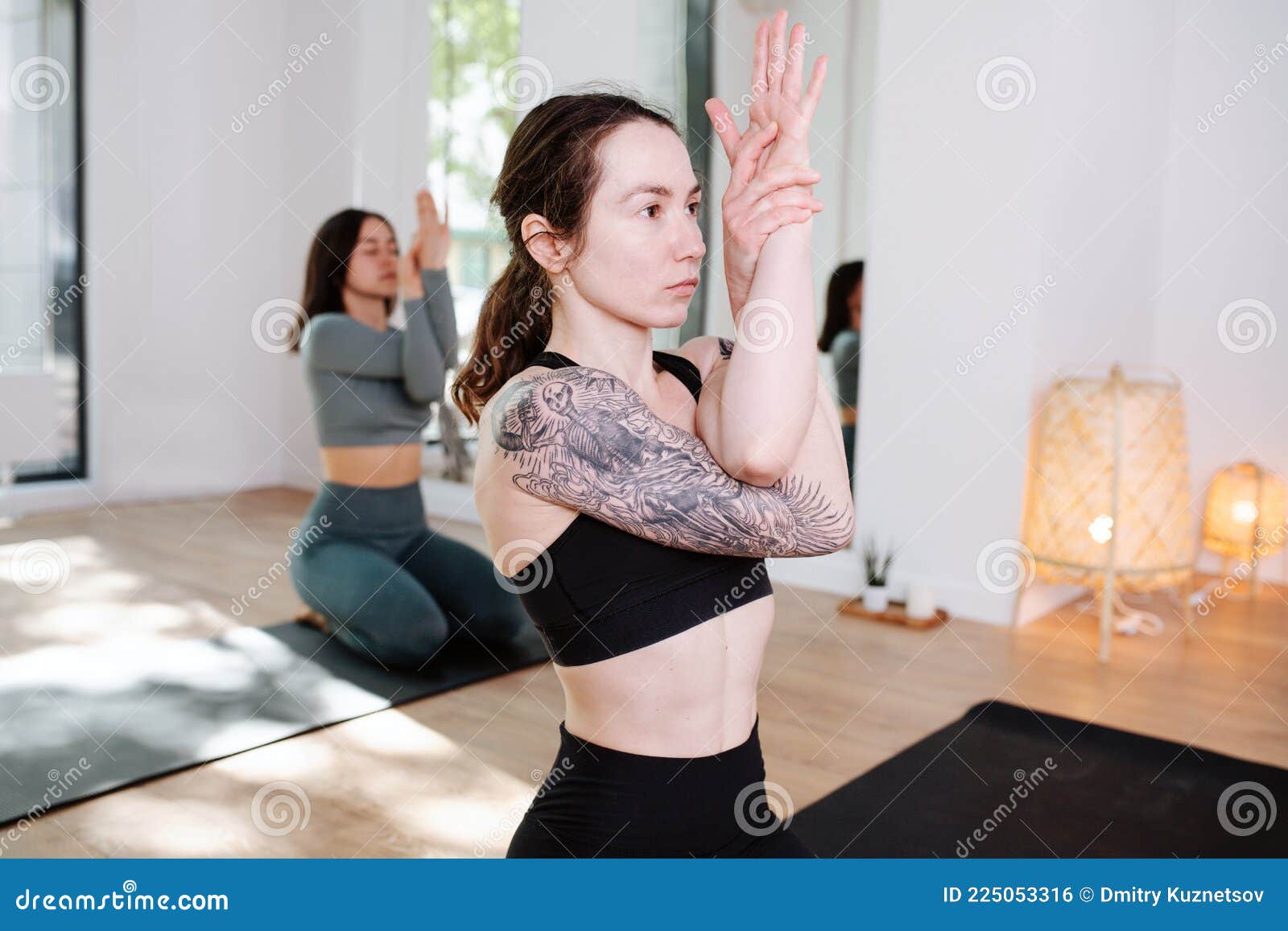 Conentrated Women Practicing Yoga in a Group, Meditating with Arms