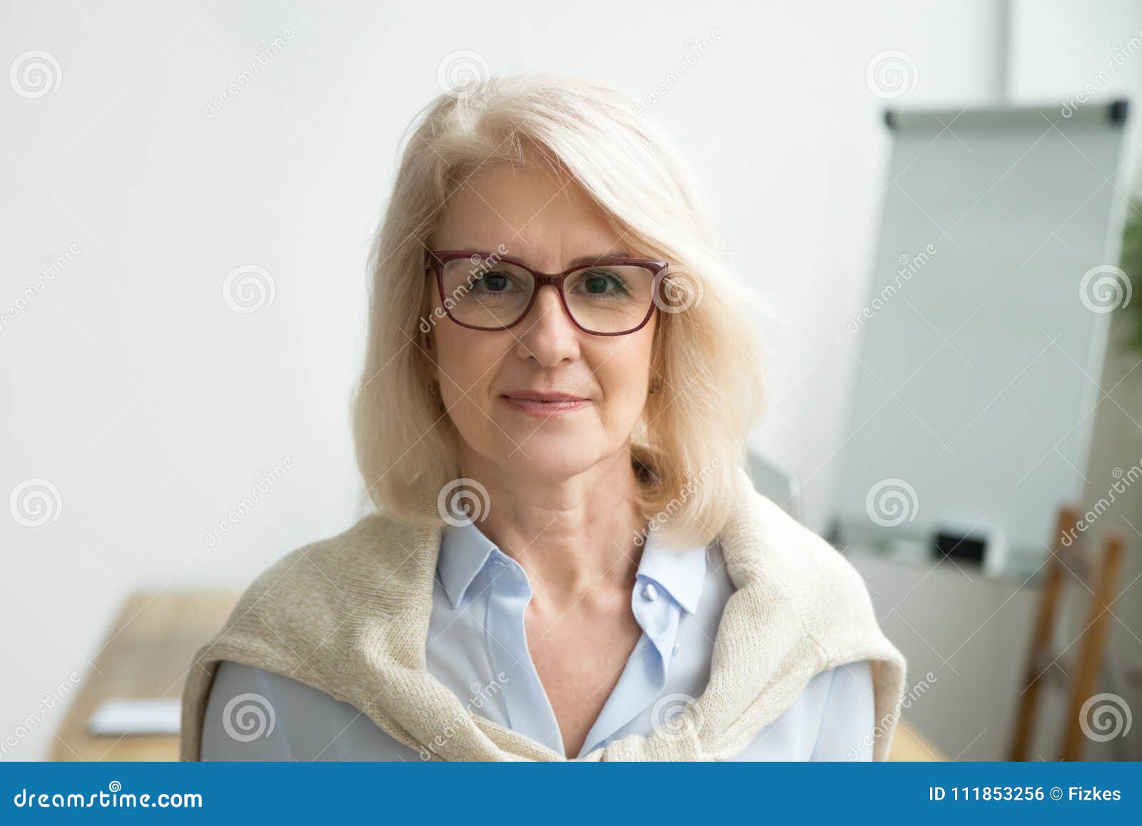 confident aged businesswoman wearing glasses looking at camera,