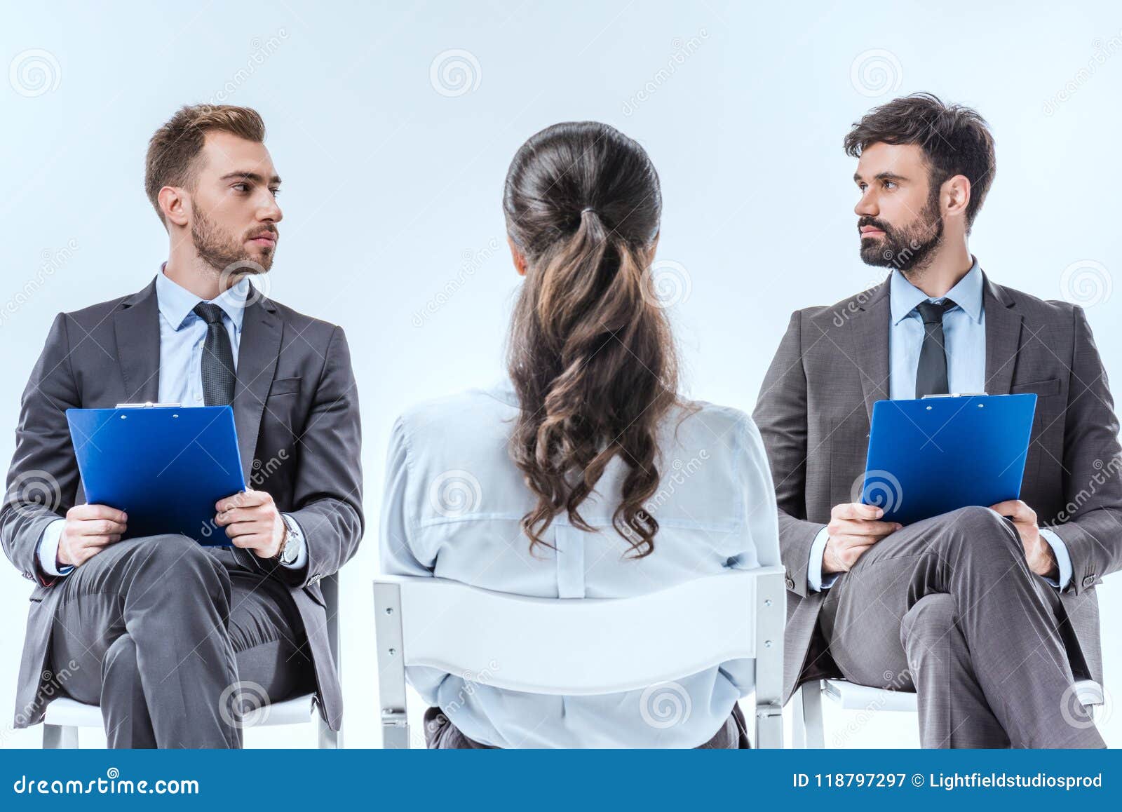 confident businessmen with clipboards looking at each other during