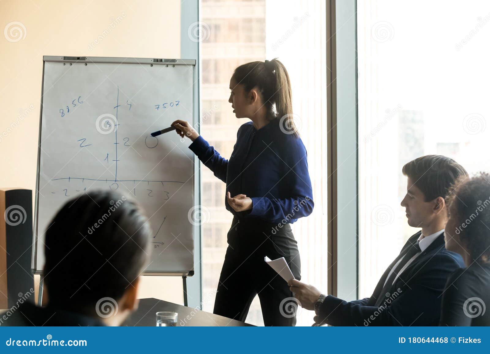 confident-businesswoman-giving-flip-chart-presentation-corporate-briefing-pointing-to-graph-female-coach-mentor-explaining-180644468.jpg