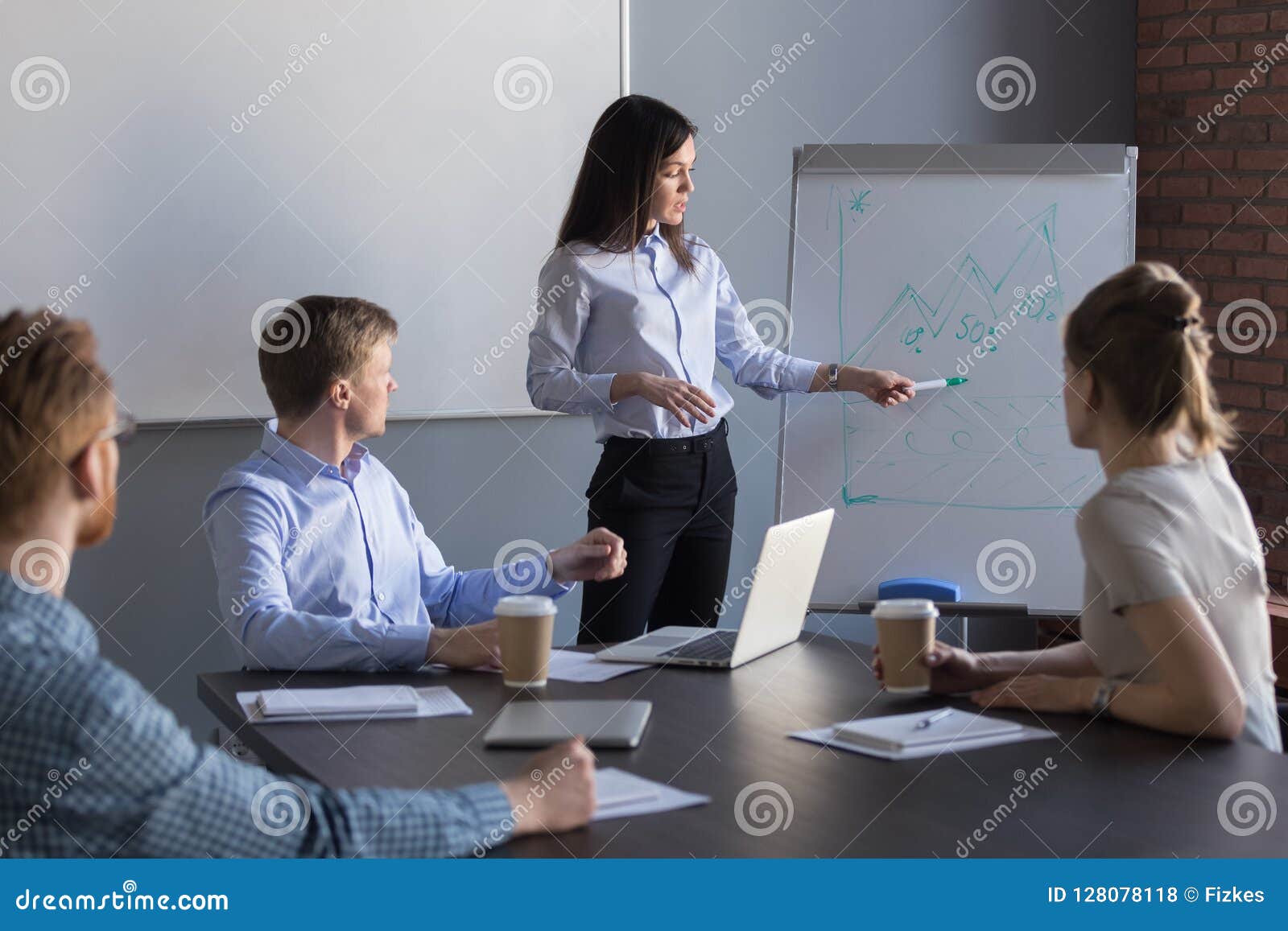 confident female team leader giving presentation in meeting room