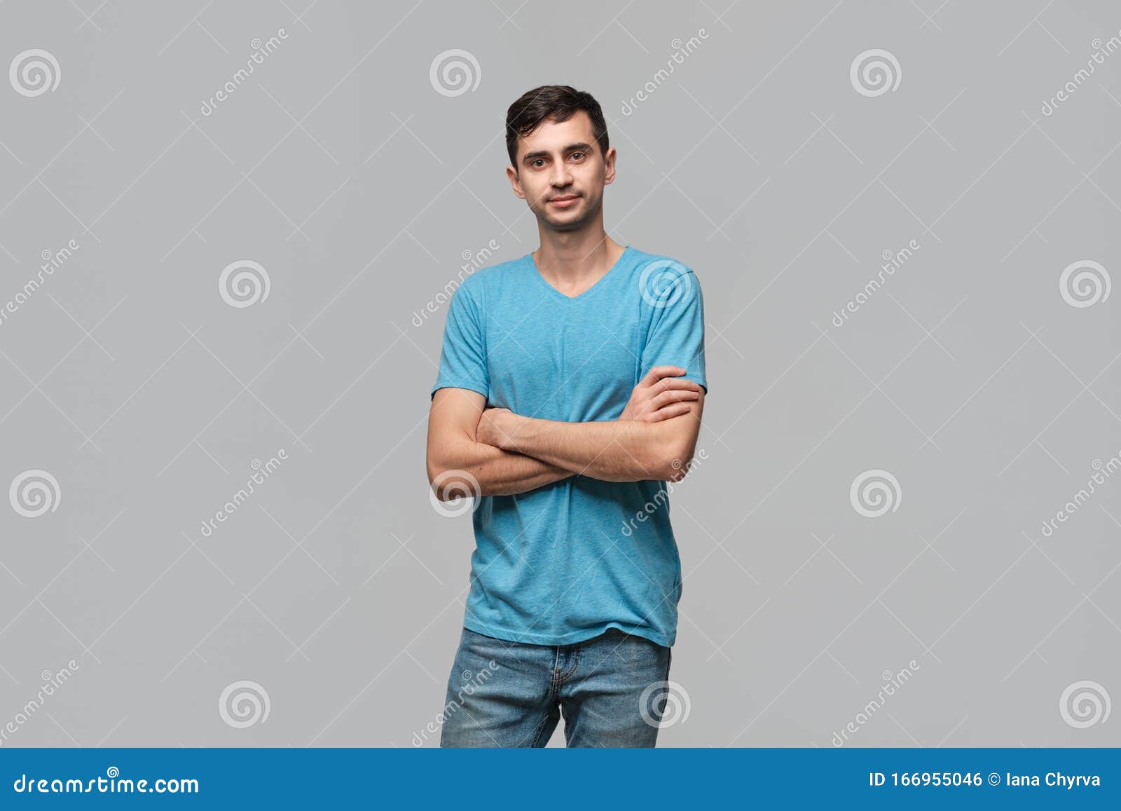 Confident Man in a Blue Tee Lookning at the Camera Holding Hands Crossed. Concept of Confidence
