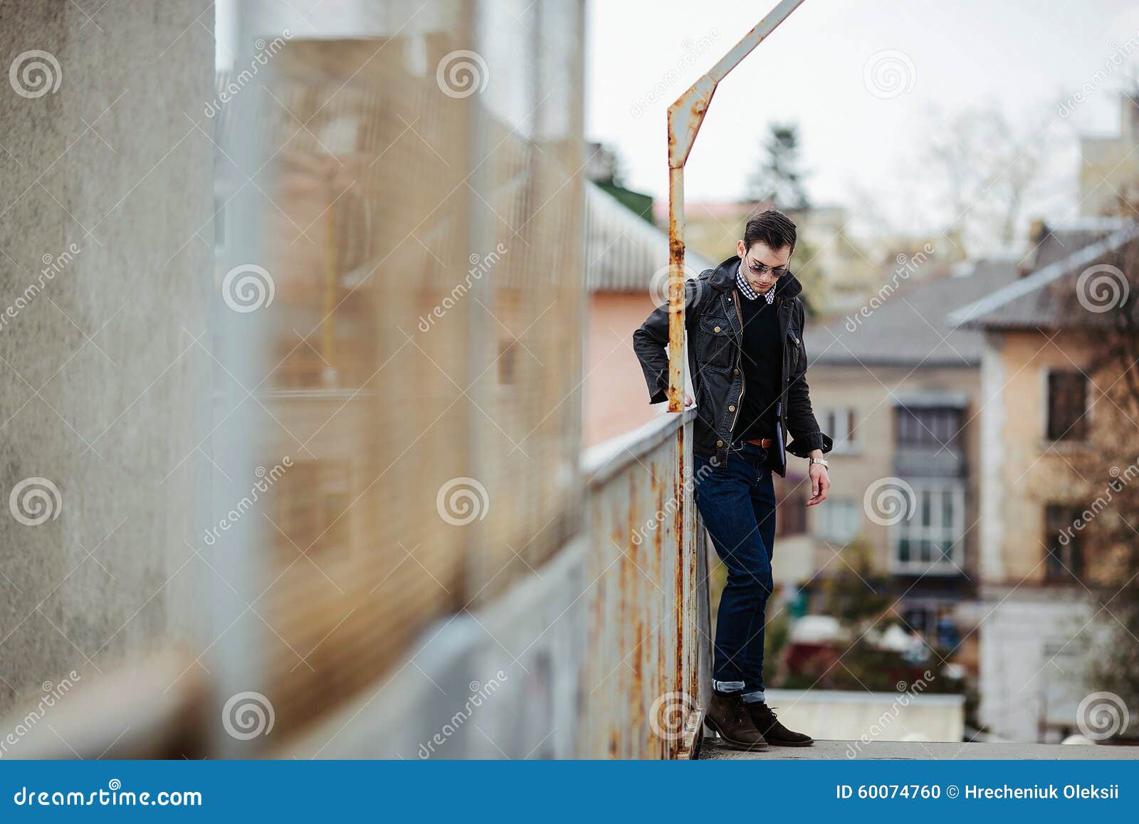 Confident man posing in selvedge jeans. A man dressed in jeans on the background of the train station