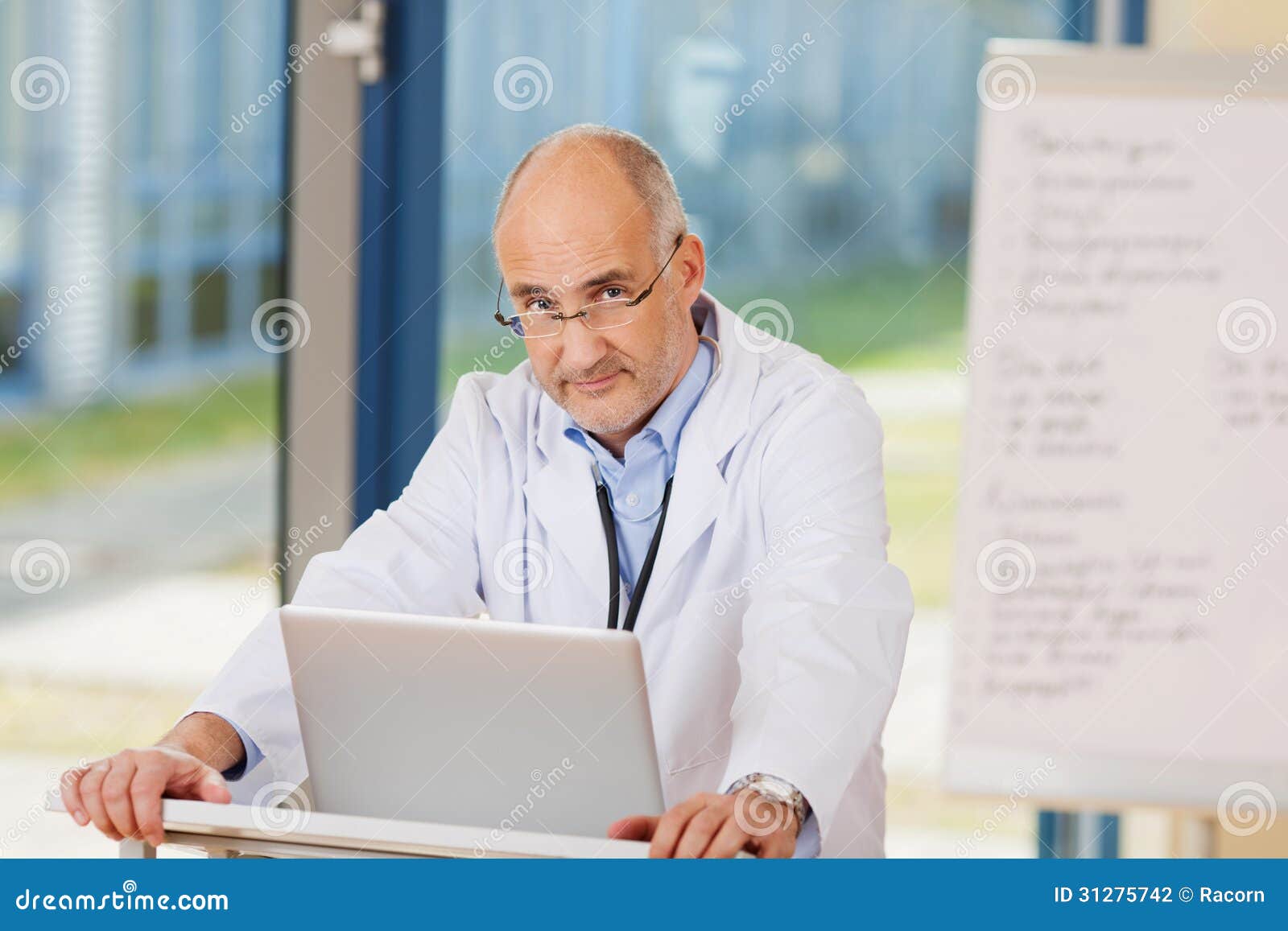 Confident Mature Doctor with Laptop at Podium Stock Photo - Image of ...