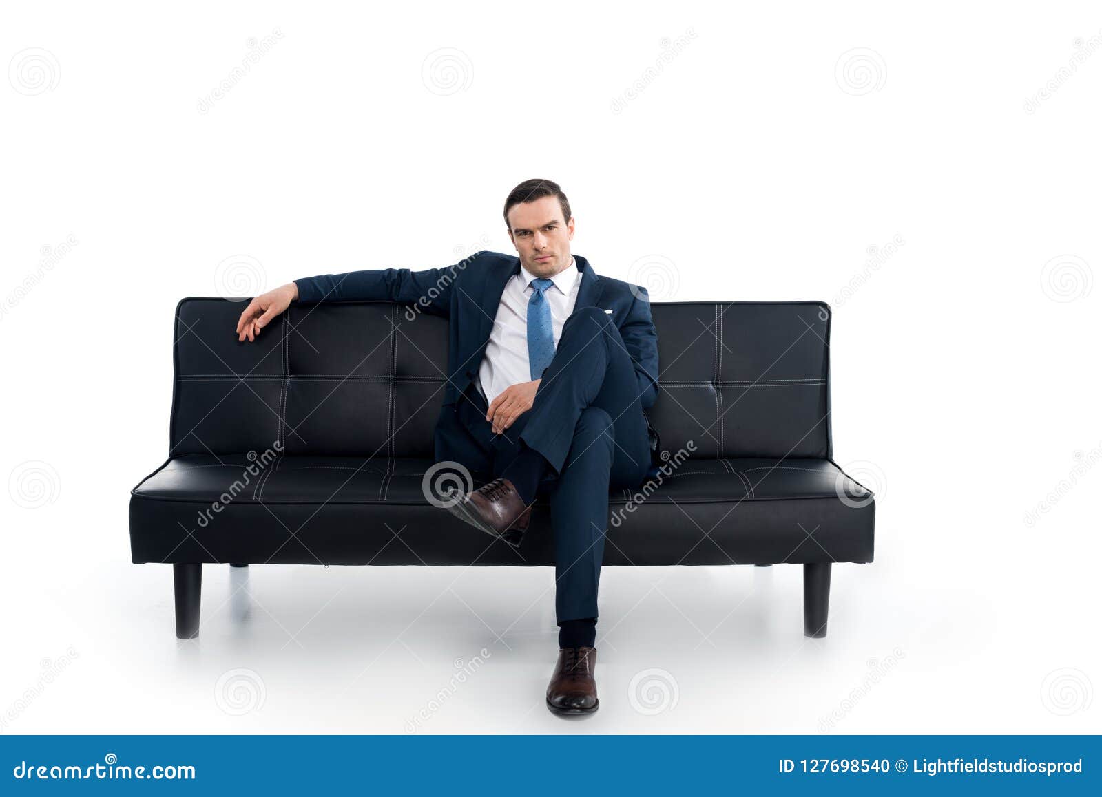 Мужчина сидит расставив ноги. Человек сидит на диване. Мужчина на диване фотосессия. Человек облокотился на диван. Чел сидит на диване.