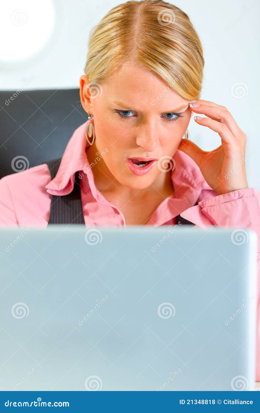 Confused business woman looking on laptop. Portrait of confused modern business woman looking on laptop