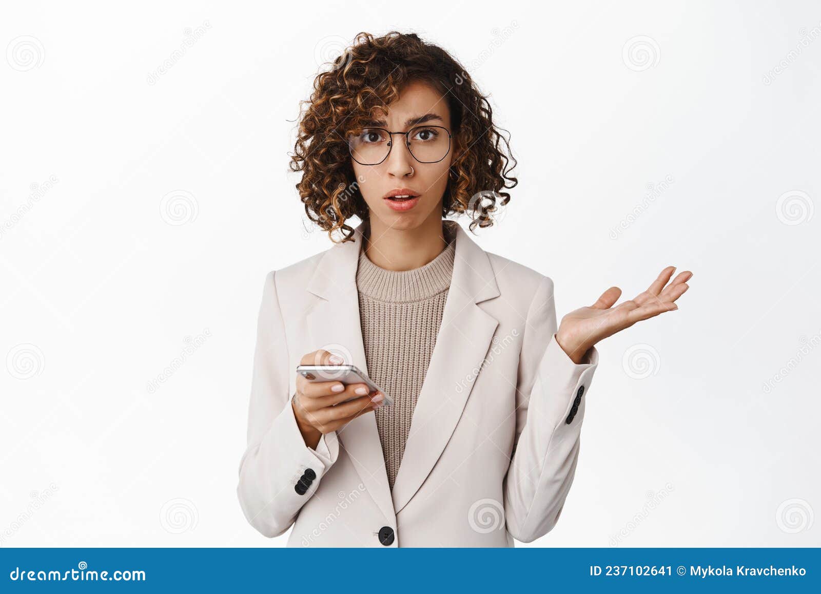 Confused Corporate Woman Shrugging Using Mobile Phone With Puzzled