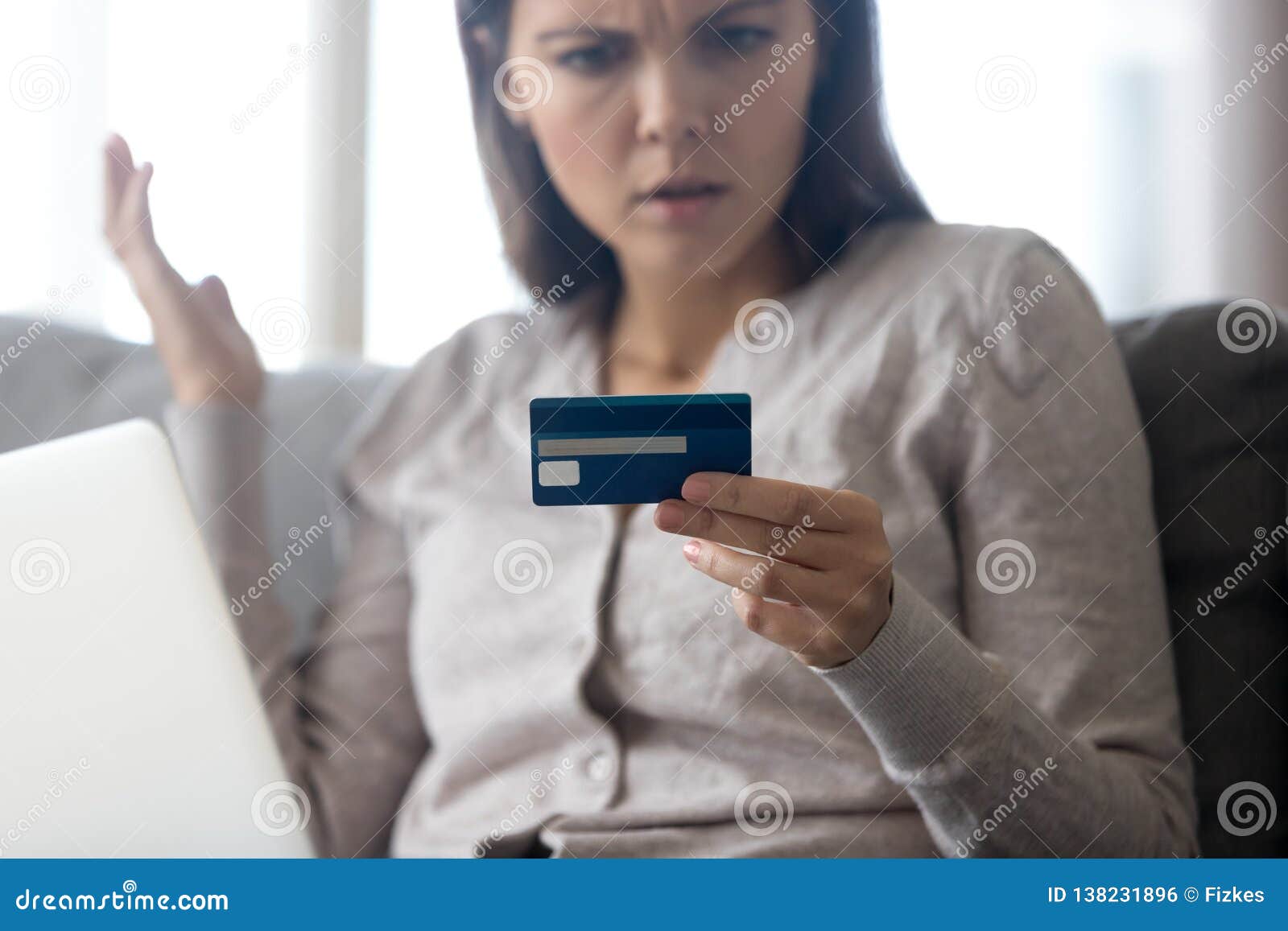 confused female customer holding credit card angry with online payment