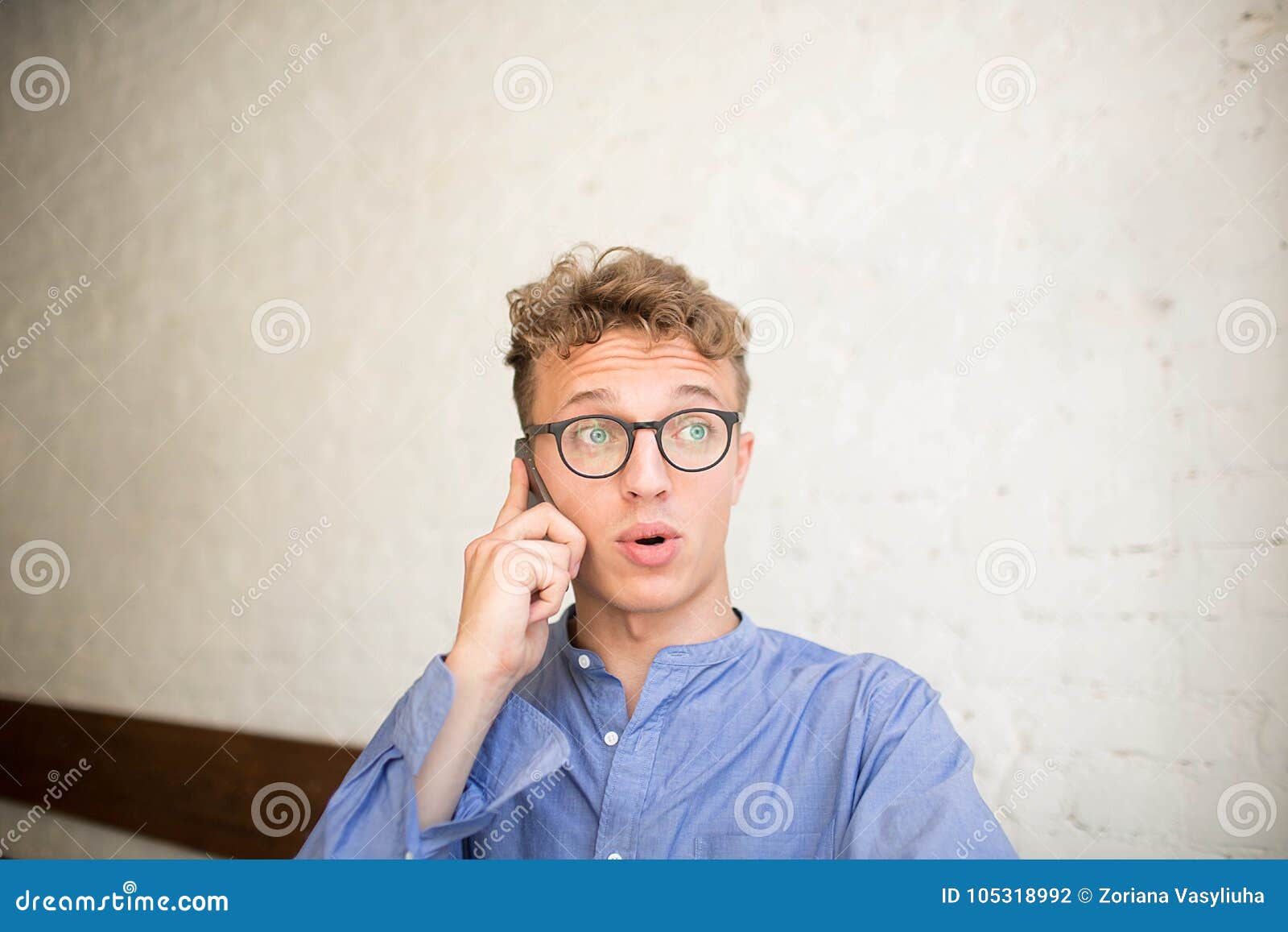Confused Hipster Man Talking Via Mobile Phone Sitting In
