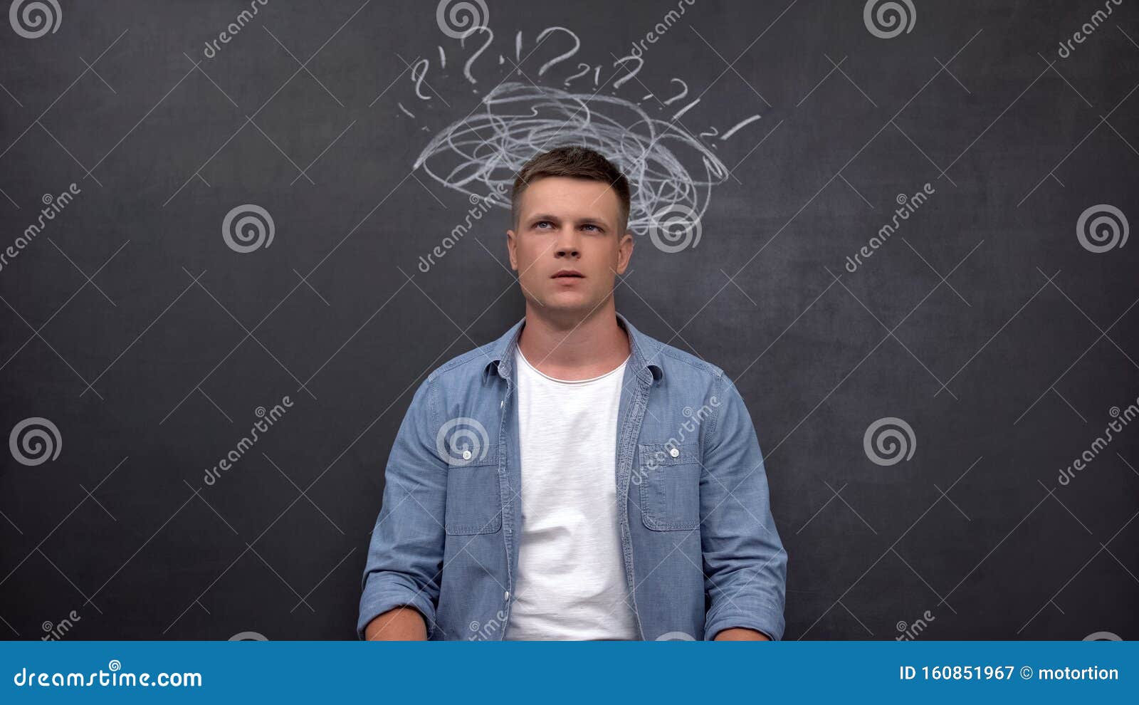 confused man standing against blackboard, searching for answer, lack of ideas