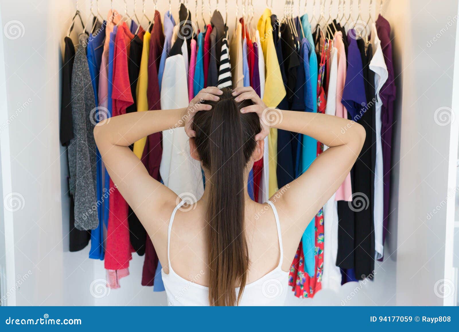 confused woman choosing what to wear in front of her wardrobe