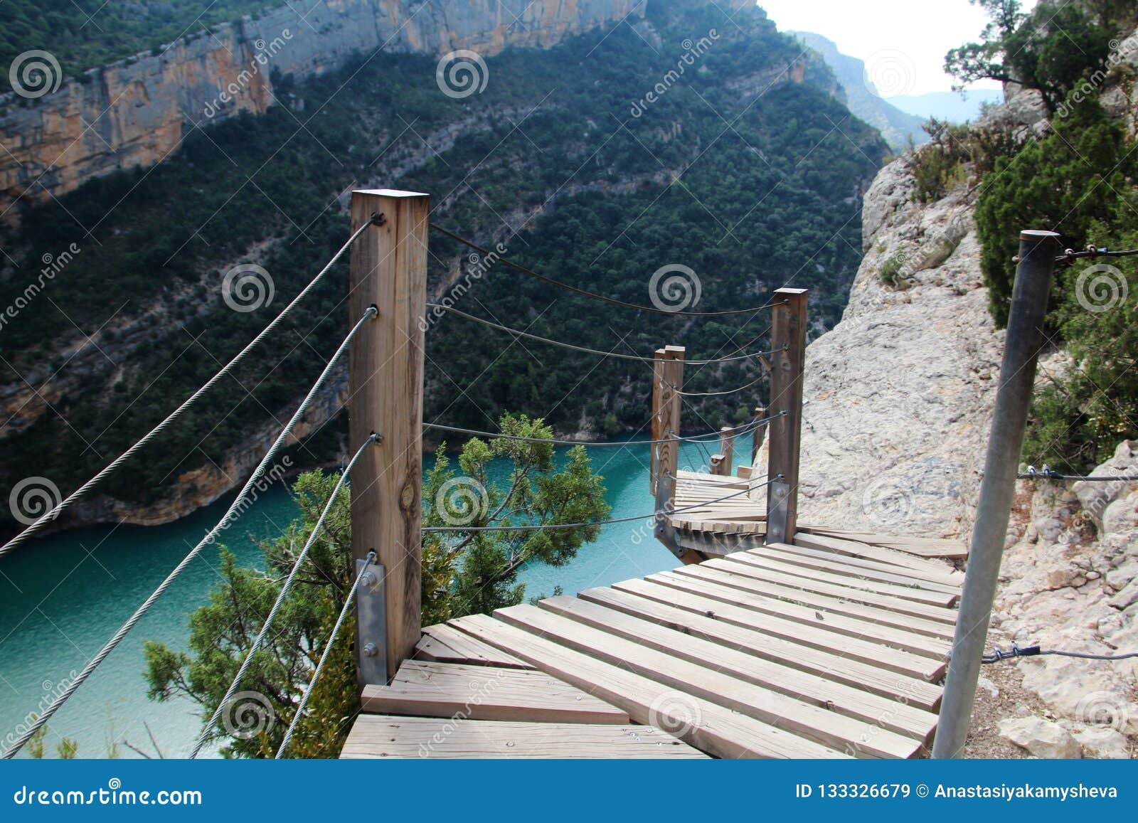 a wooden staircase at rock cliff as part of hiking path in mont rebei canyon, spain