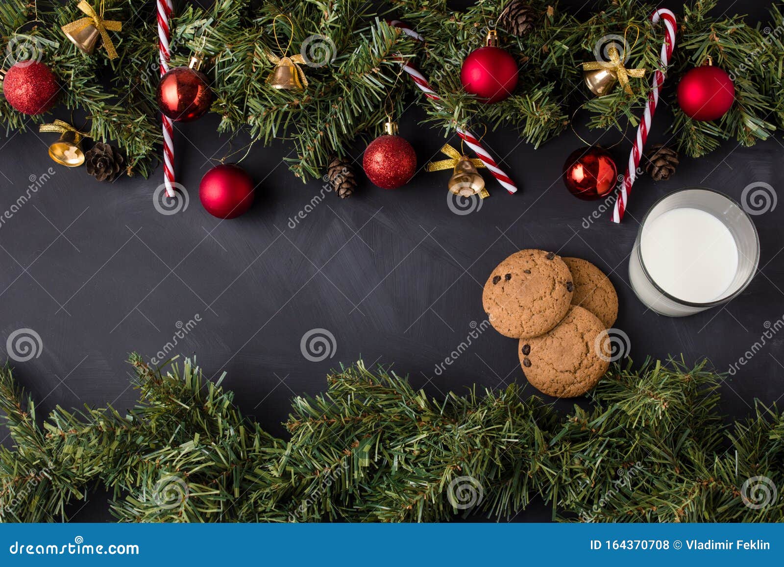 Coniferous Christmas garland decorated with red balls and golden bells with caramel canes at the top and bottom of the black table as well as a song with milk from the right side.