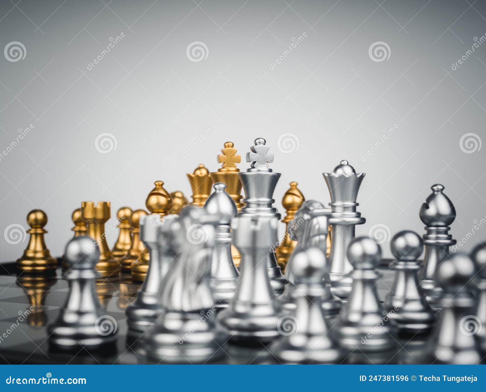A peça de xadrez do bispo de ouro na frente dos peões de ouro no